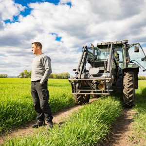 Landwirt mit Traktor im Getreidefeld - unternehmerische Freiheit und Zukunftssorgen